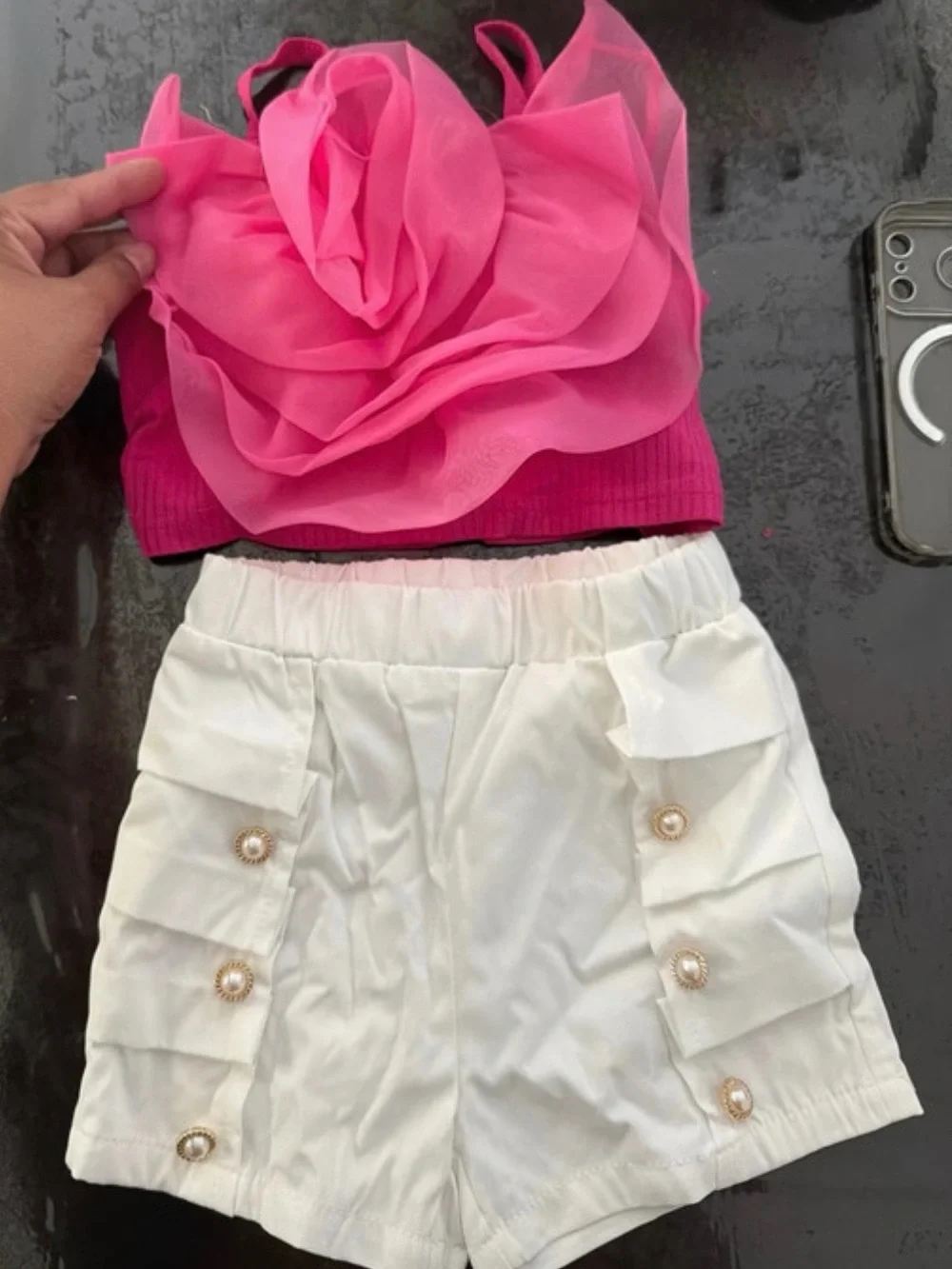 Es un set de niña de SHEIN, talla 4, que incluye:  * 🎀 Blusa/top rosa con una fl